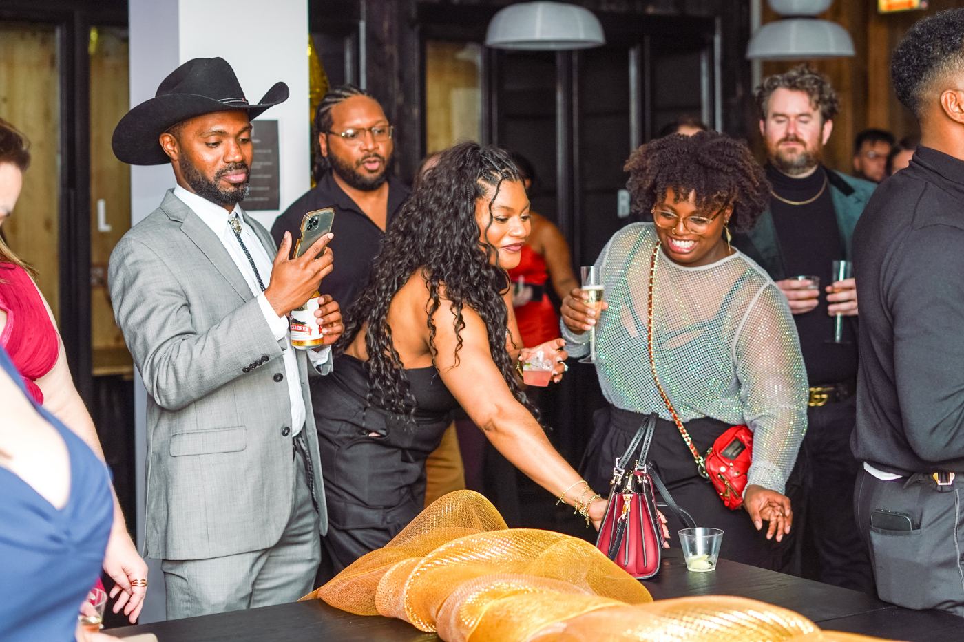 Members dressed up and laughing around the table at a Three Cities Social party